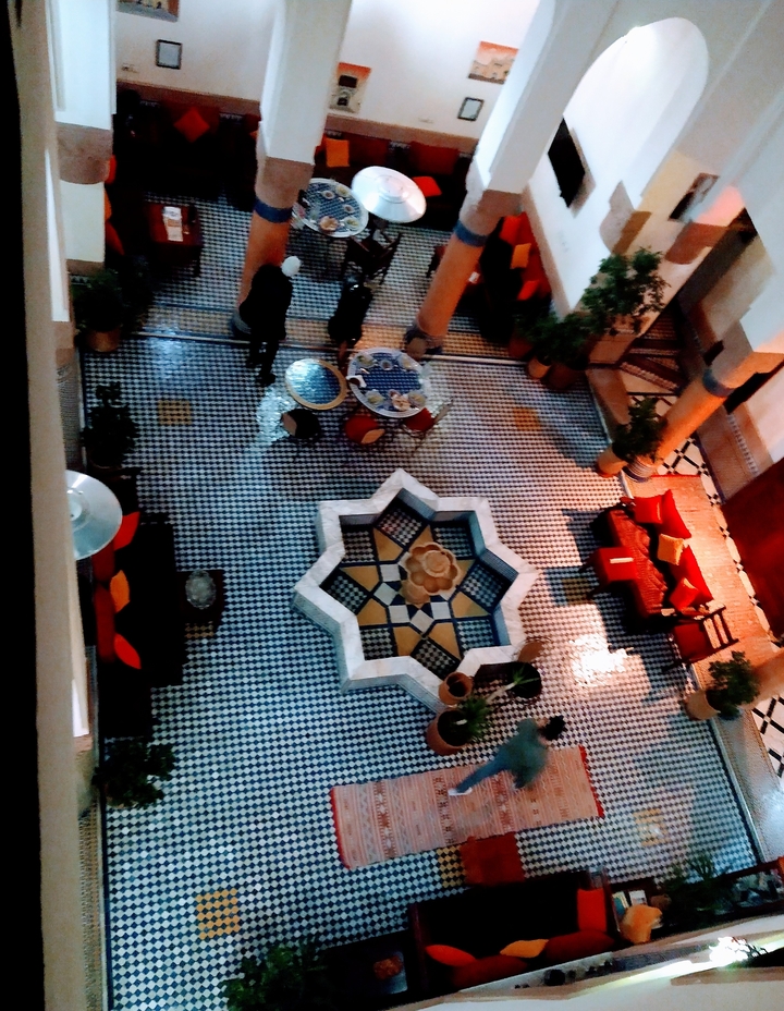 A traditional Moroccan courtyard with a star-shaped fountain.