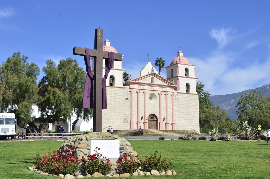 Bâtiment de mission historique avec une croix au premier plan.