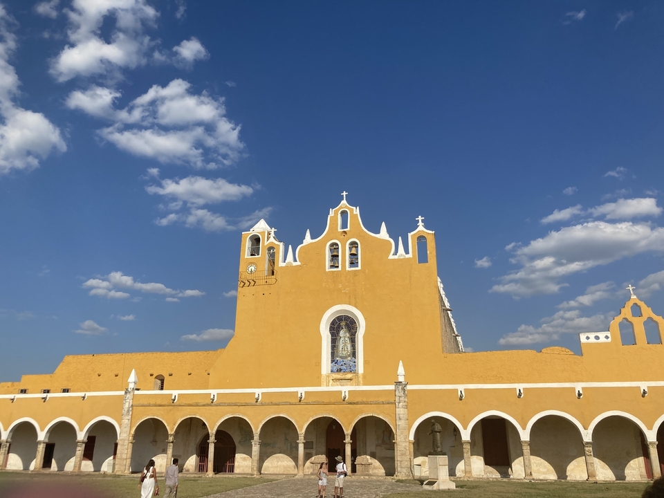 Church facade with bell towers under a blue sky.