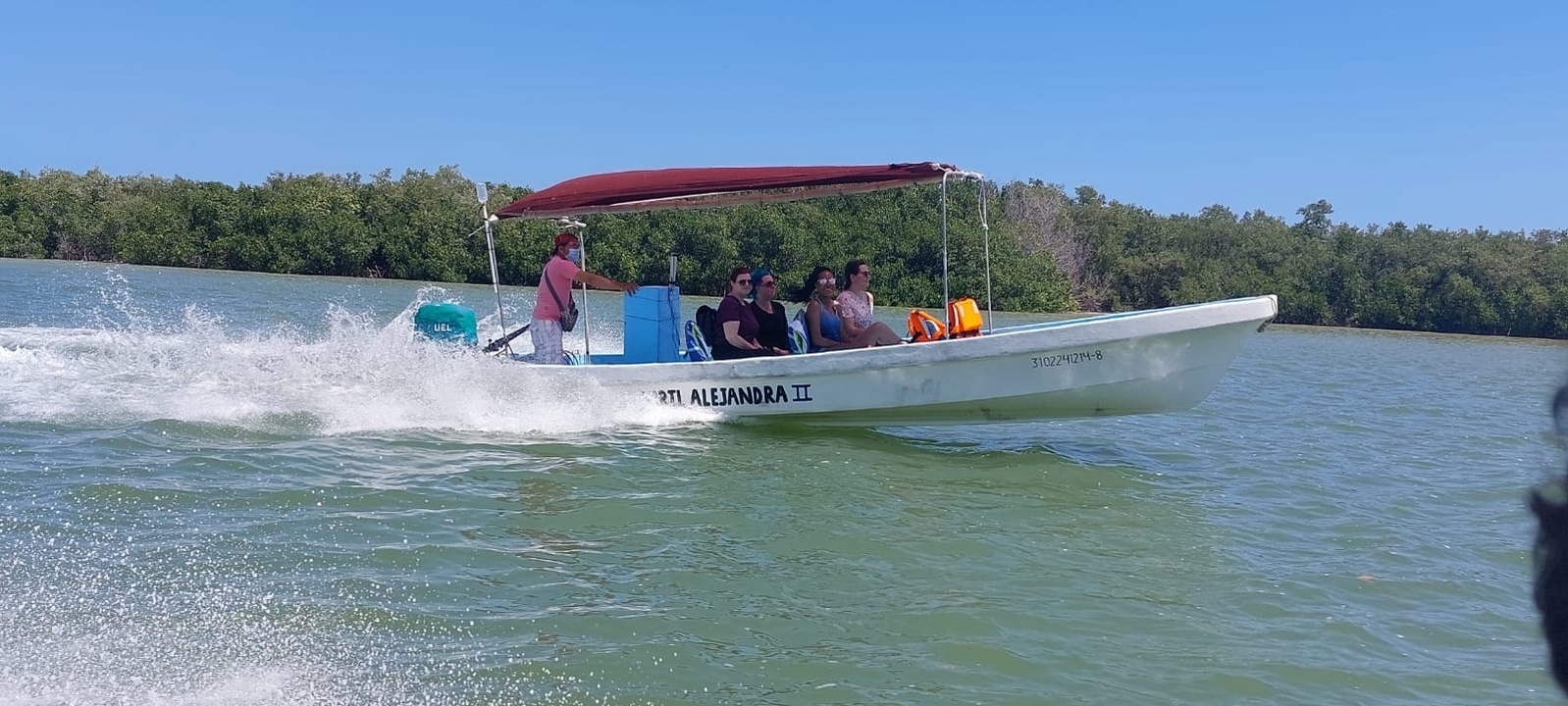 Boat with people cruising on a lake.