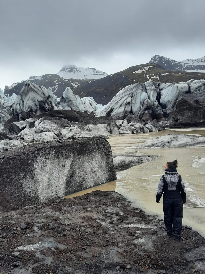 Woman standing in front of a glacier.