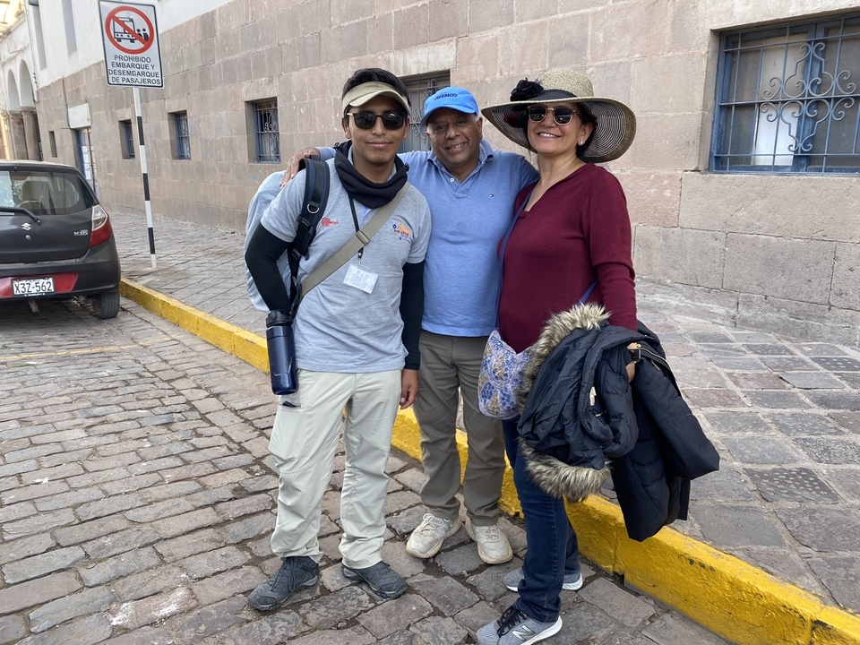 Group of tourists standing on a cobblestone street.