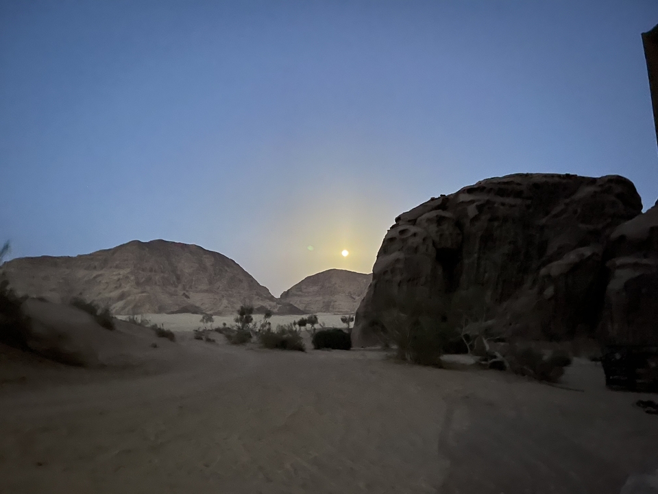 Dusk view of a desert landscape with rocky hills.