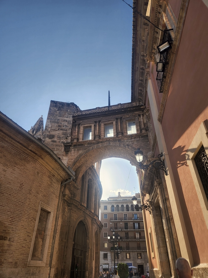 Historical archway with city buildings.