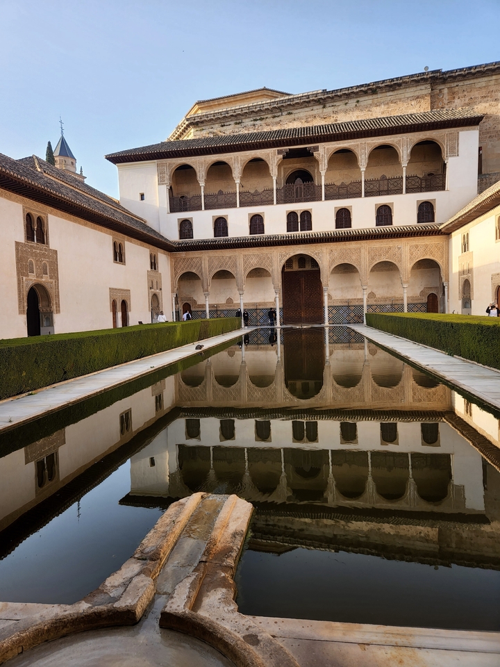Reflecting pool courtyard with arches.