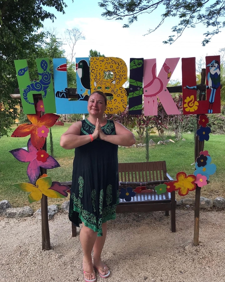 Person posing with colorful floral signs.