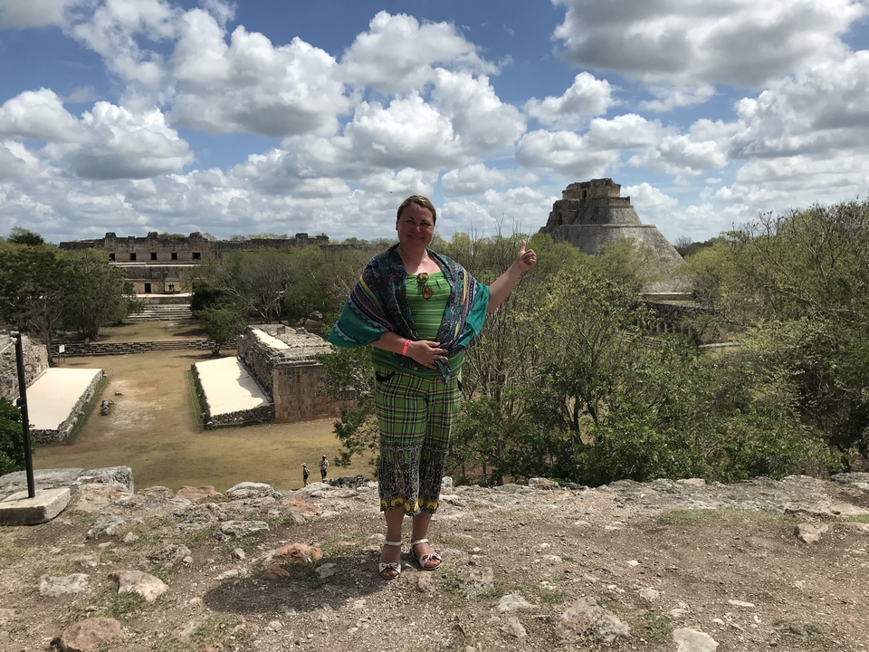 Person pointing at the Pyramid of the Magician in Uxmal.