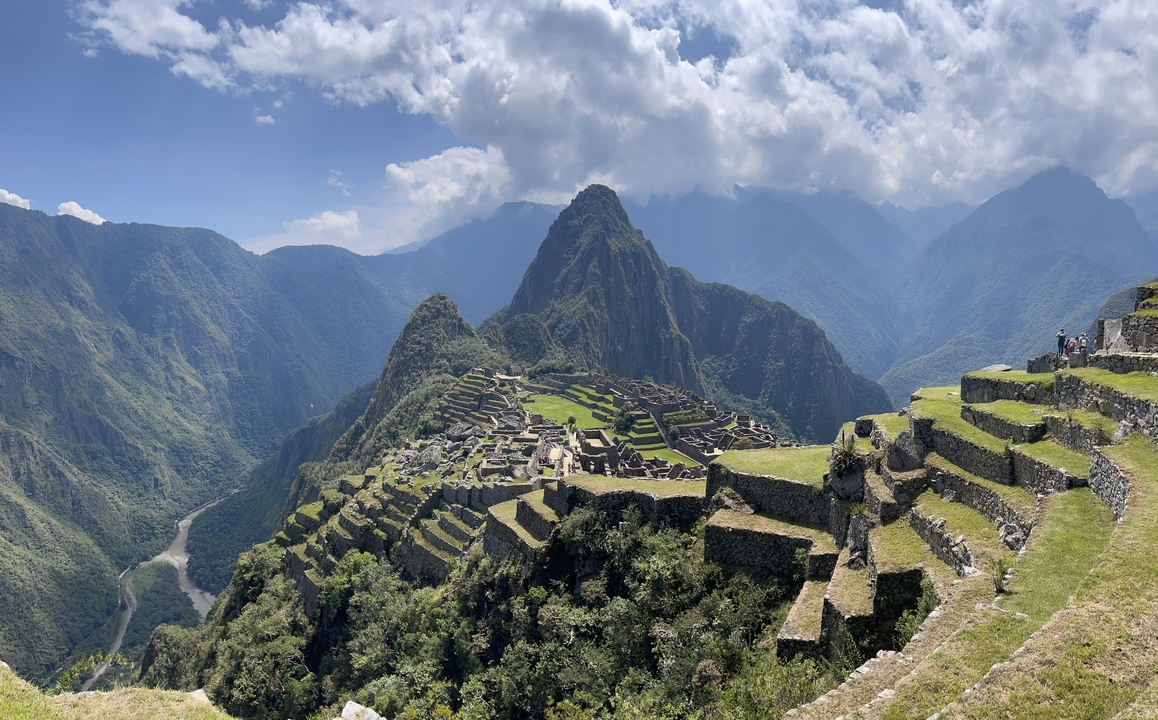 Panoramic view of Machu Picchu surrounded by mountains.