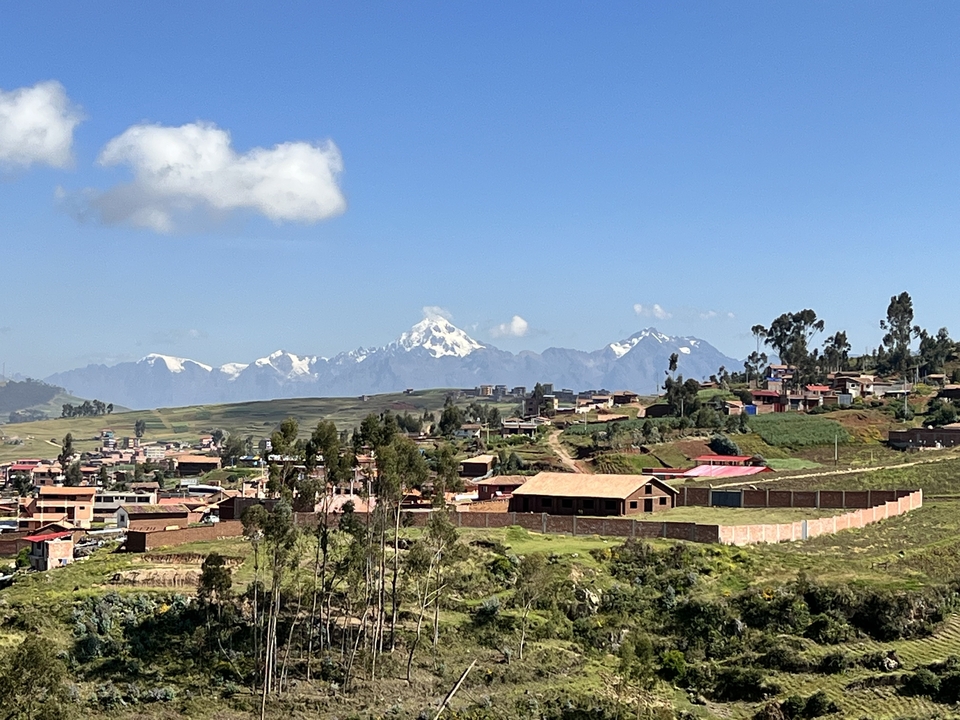 View of a village with snow-capped mountains in the background.