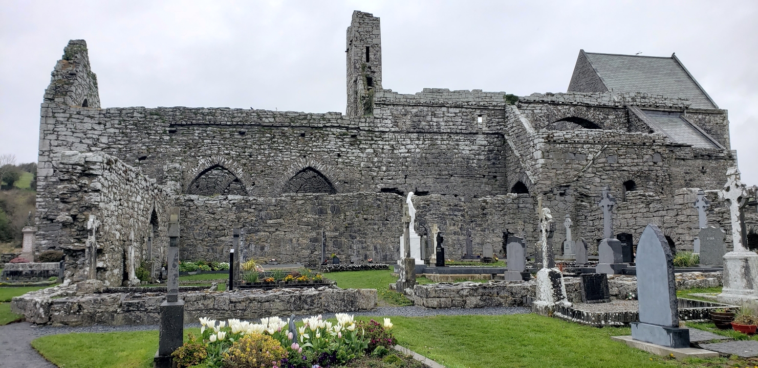 Old stone abbey ruins with a graveyard.
