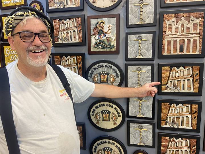 Man pointing at souvenirs with Petra imagery.