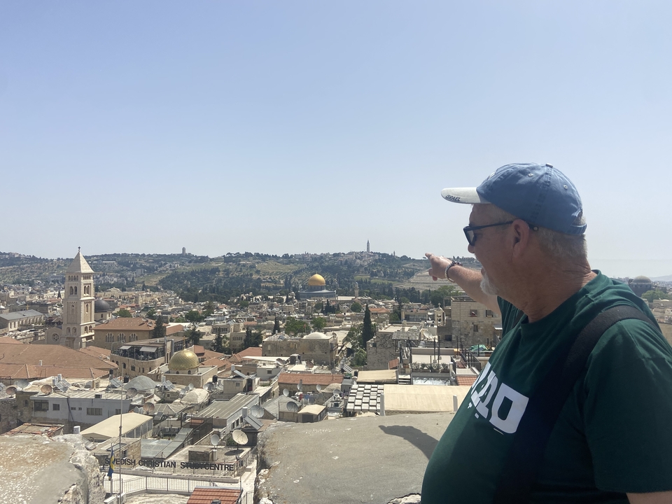 Man pointing towards the cityscape of Jerusalem.