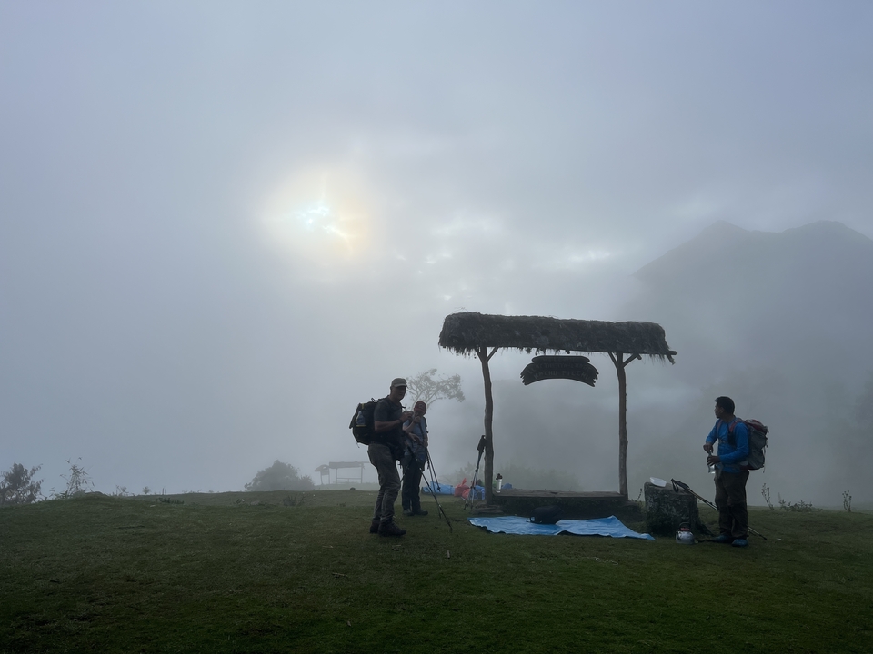 Hikers resting with a misty mountain backdrop.