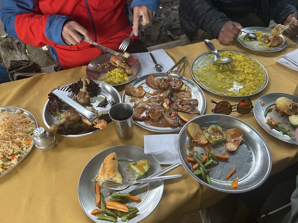 Platters of food including meats and grains at a dining setting.