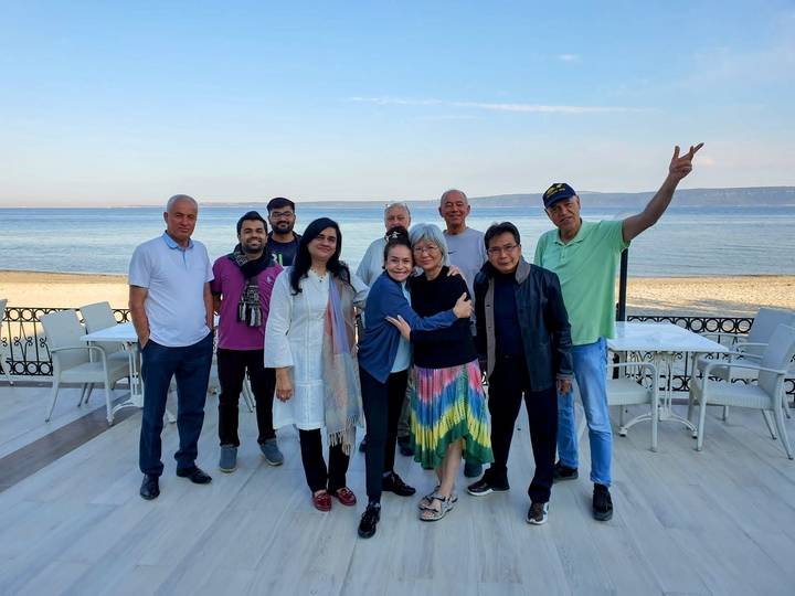A group of people posing in front of a seascape.