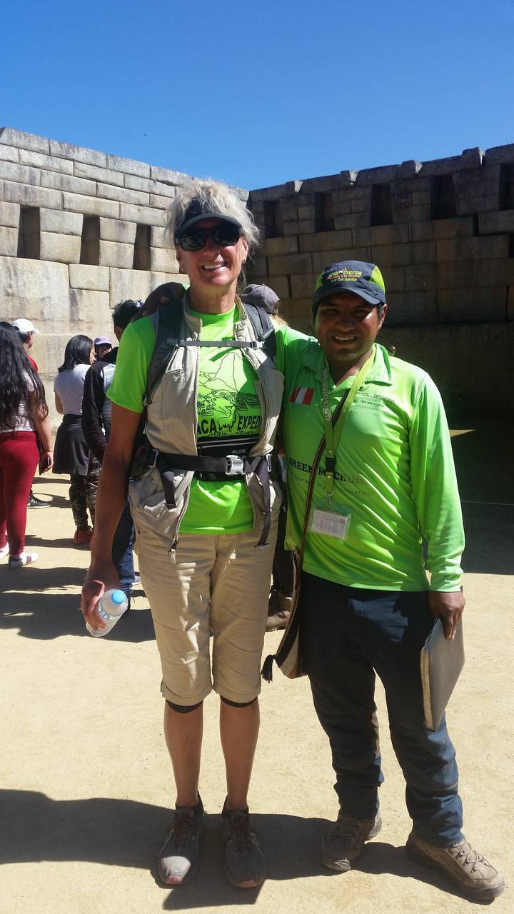 Two people posing in front of ancient stone walls.