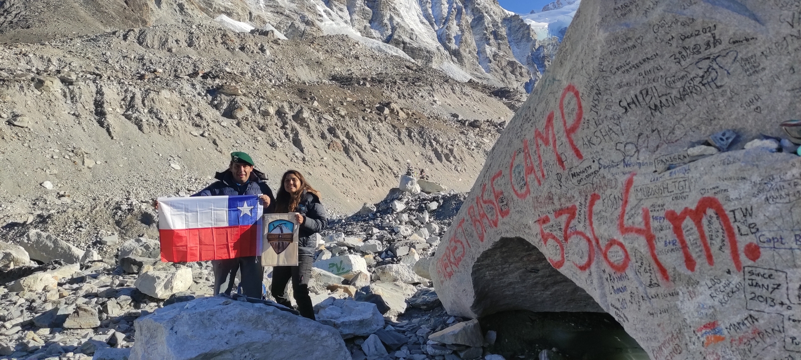 Two people with flags at base camp.