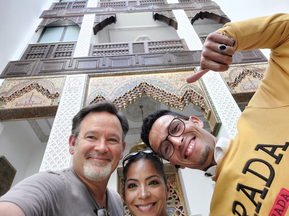 Three friends taking a selfie in front of intricate Moroccan architecture.