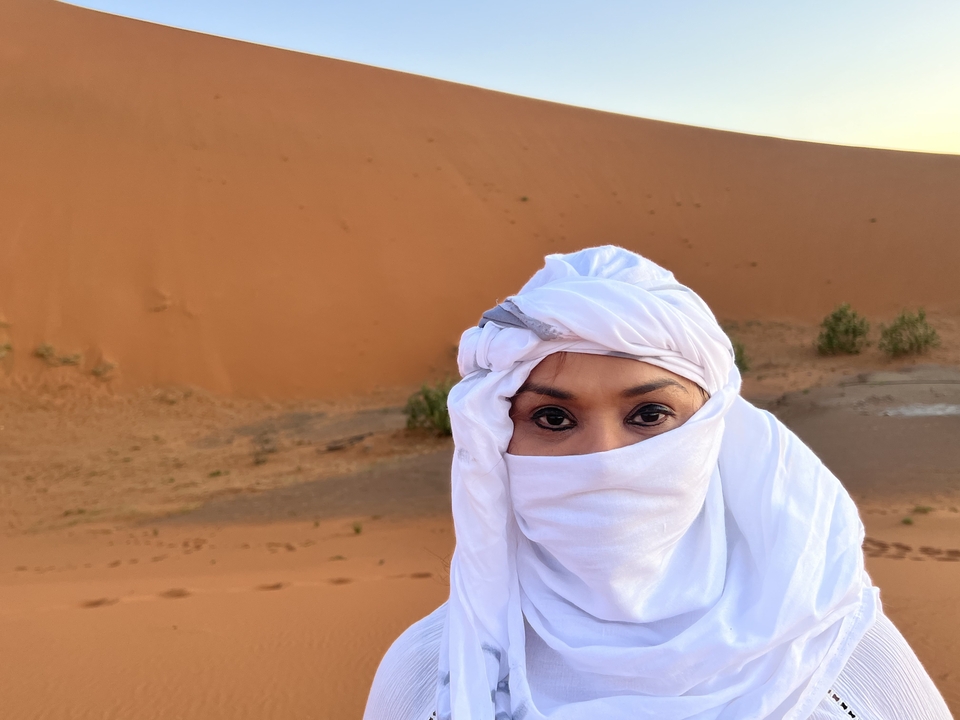 Personne en costume traditionnel dans le désert.