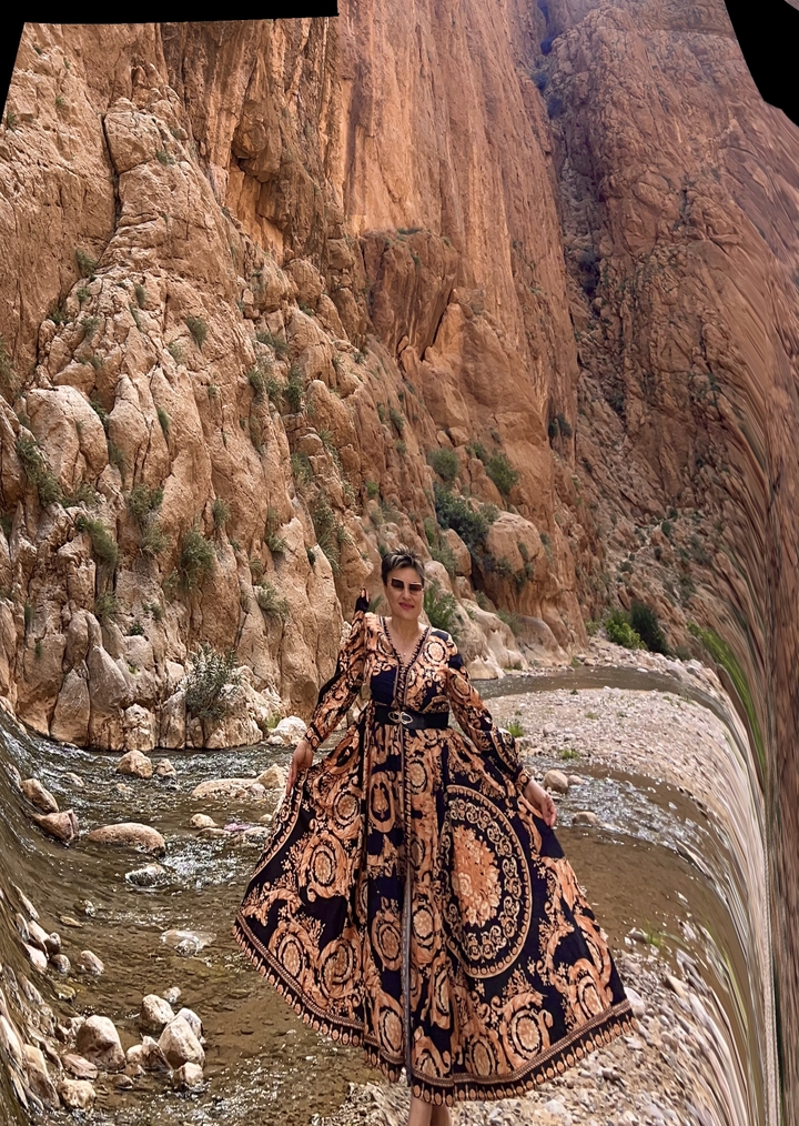 Personne debout au bord d'une rivière dans un canyon.