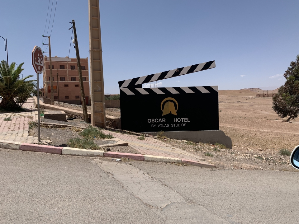 Sign for Oscar Hotel by Atlas Studios on a roadside.