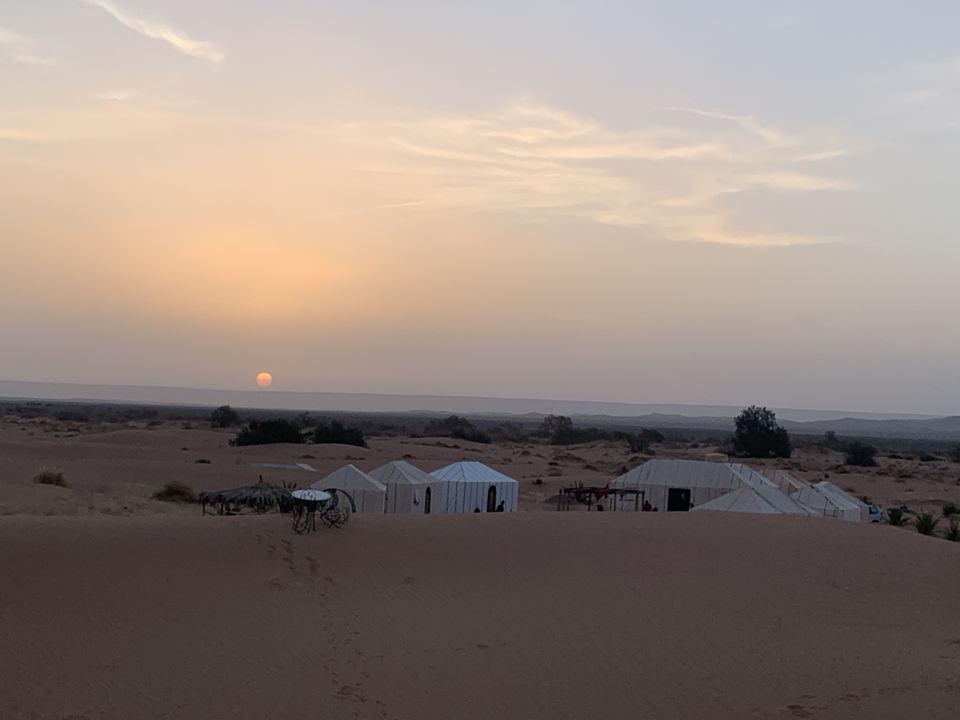 Desert camp with tents at sunset.