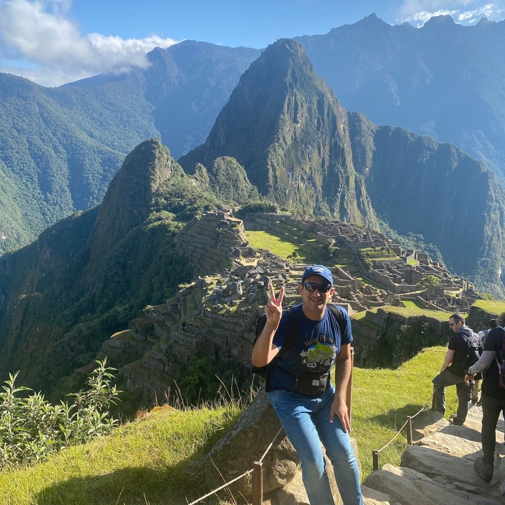 Une personne qui pose devant les ruines du Machu Picchu.