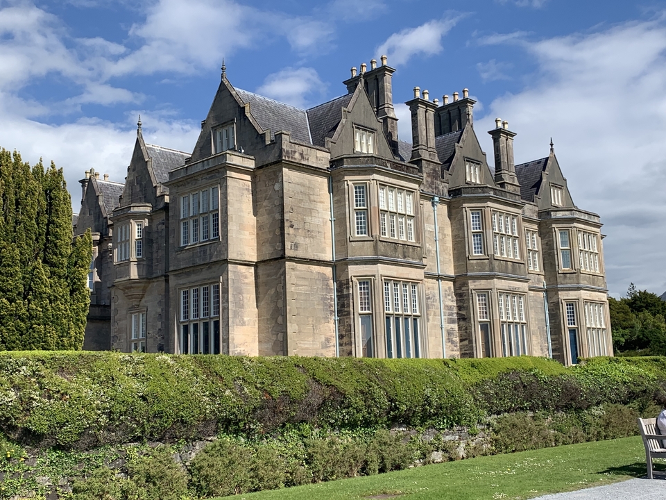 A grand historic mansion surrounded by greenery.