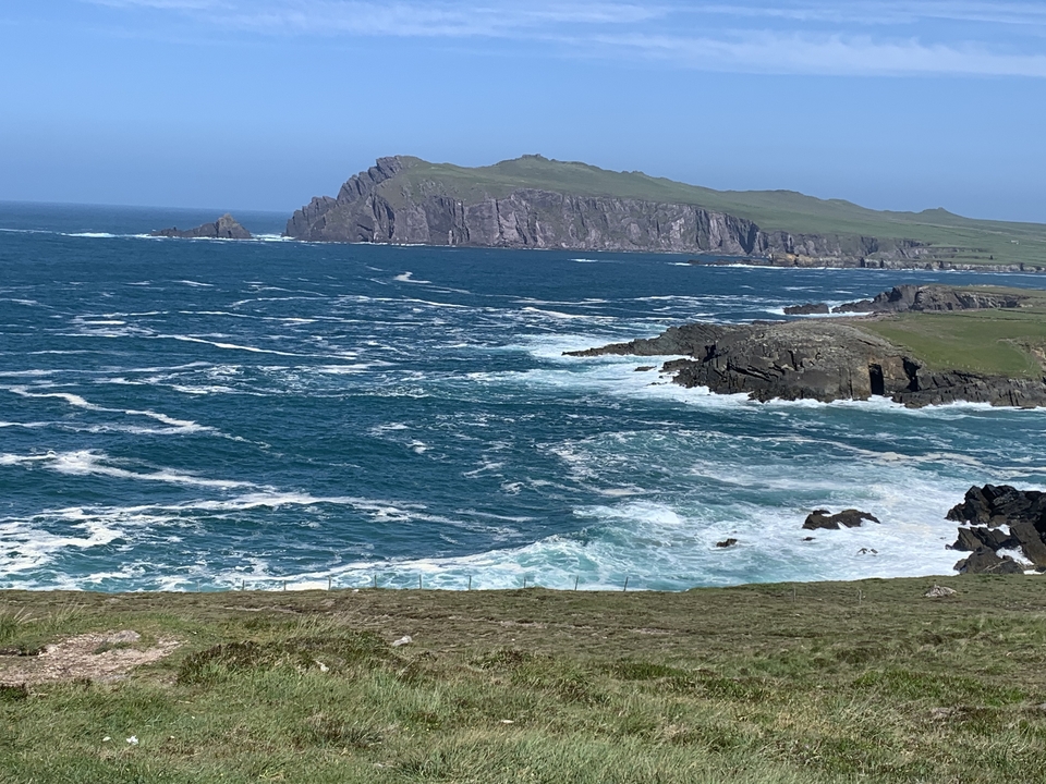 Coastal cliffs with sharp rock formations and waves.