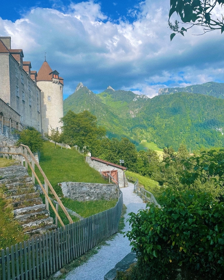 A medieval castle nestled against a mountainous landscape.