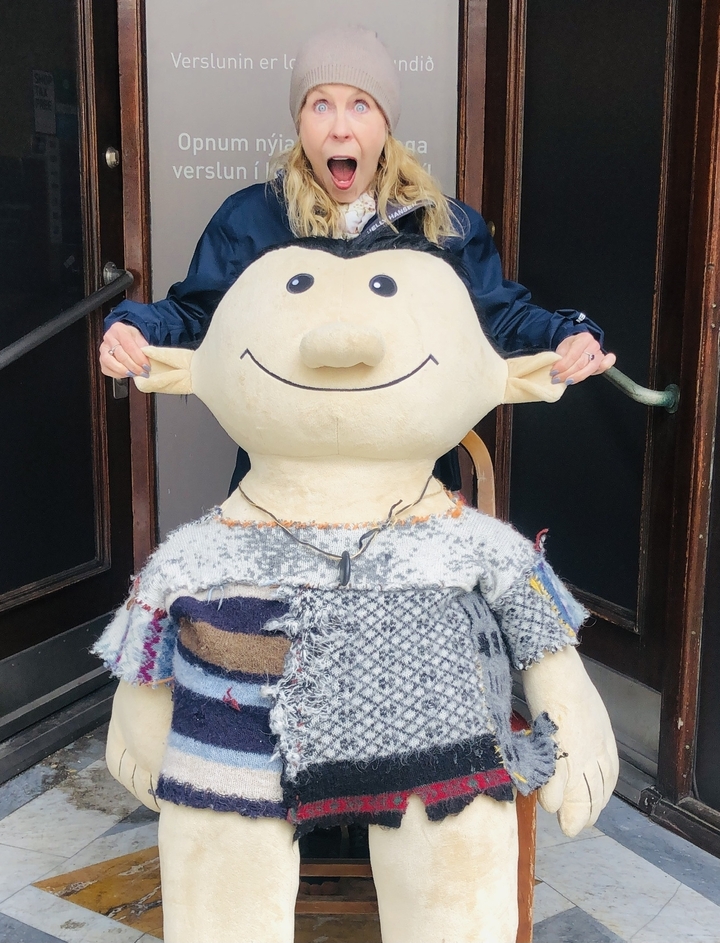 Person with a large toy figure in a playful pose.