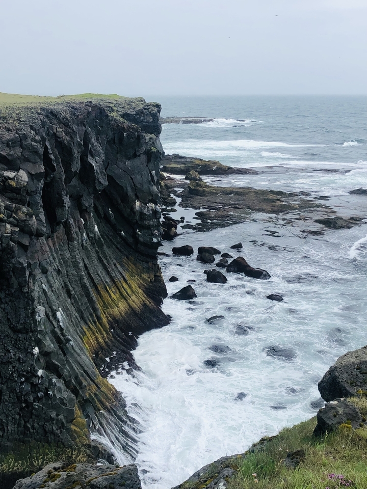 Rocky coastal landscape with waves crashing.