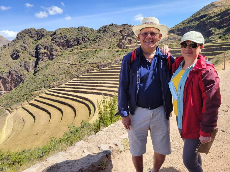 Couple smiling in front of terraced hills.