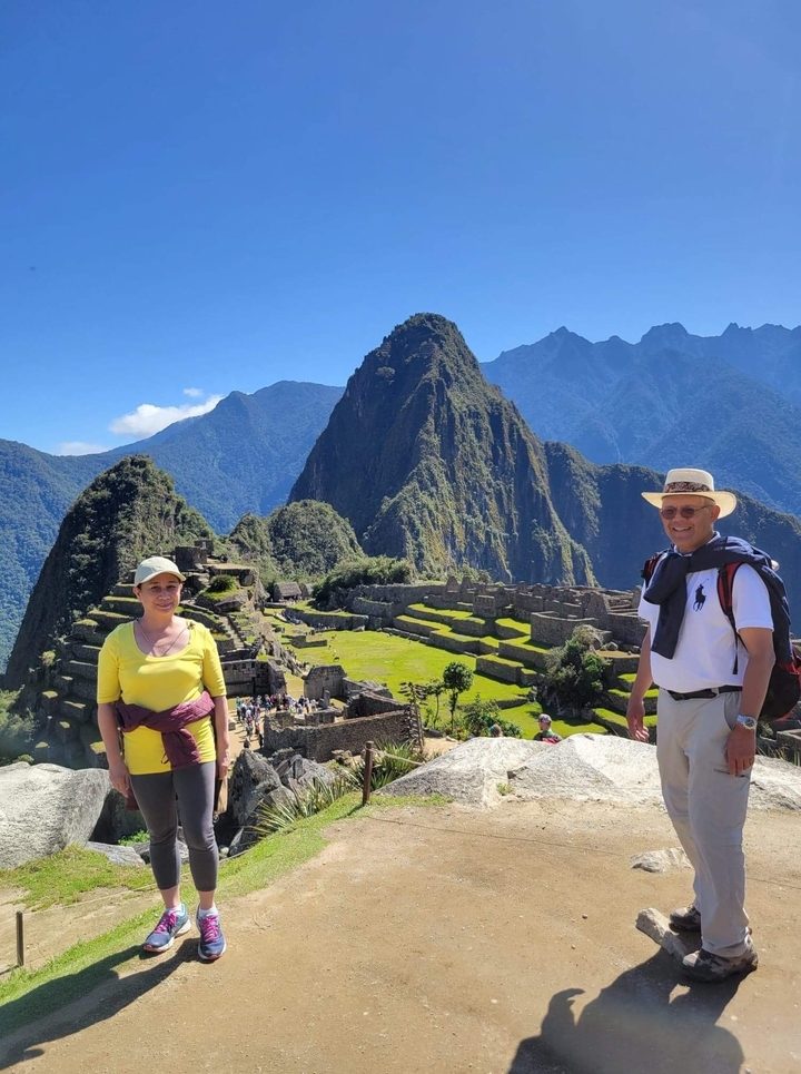 Tourists posing with the iconic peak of Machu Picchu.