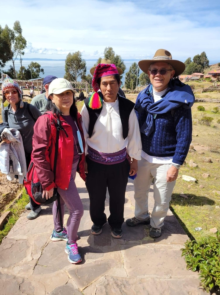 Couple with a local in traditional garments outdoors.