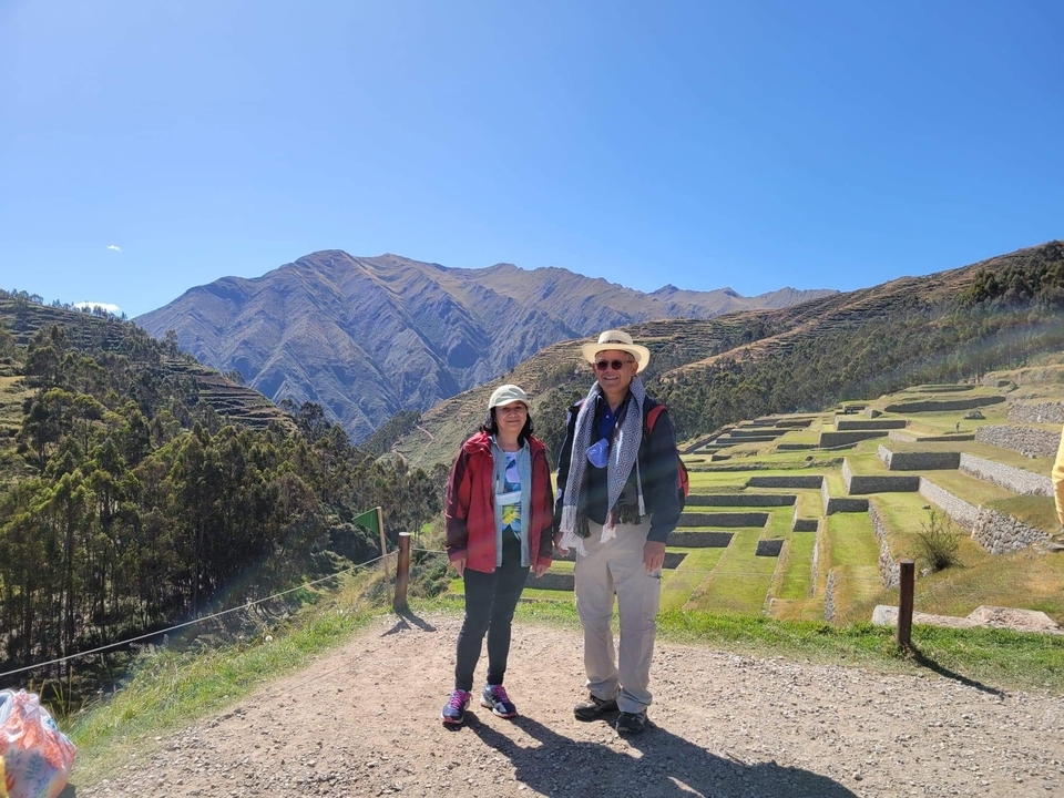 Couple posing with mountain terraces in the background.