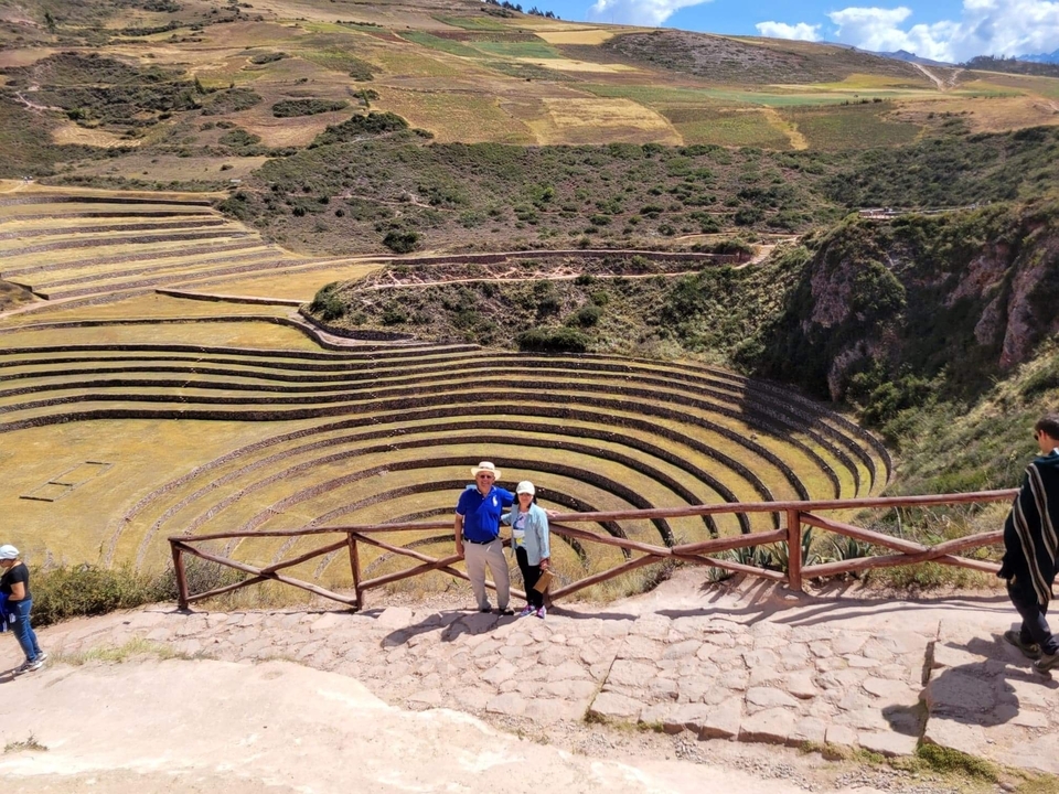 Couple standing near circular agricultural terraces.