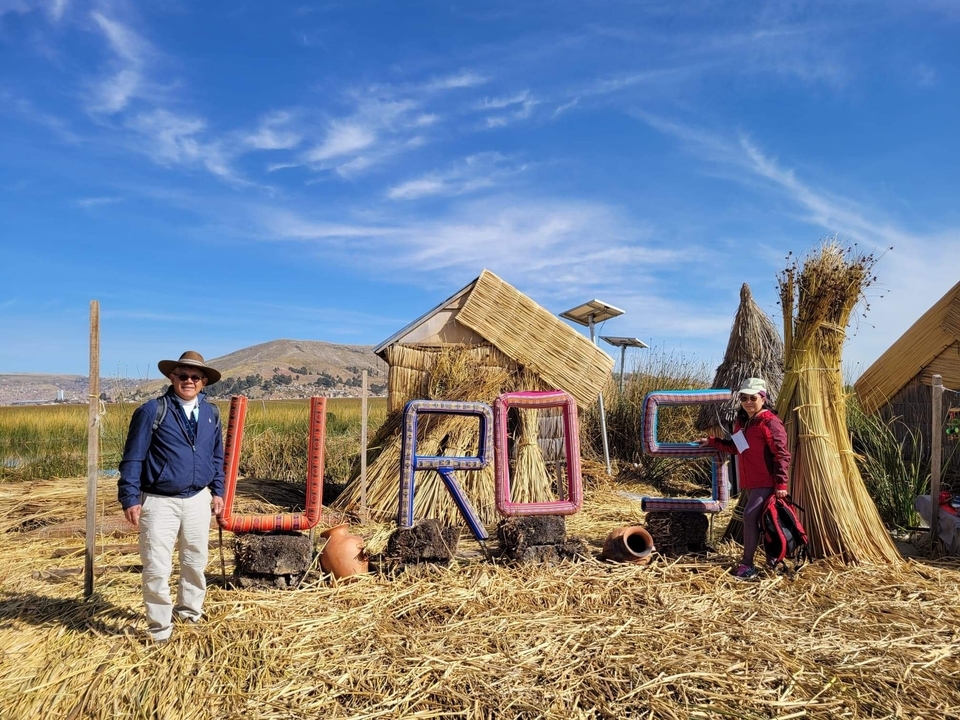 Couple posing with a sign for Uros Reed Islands.