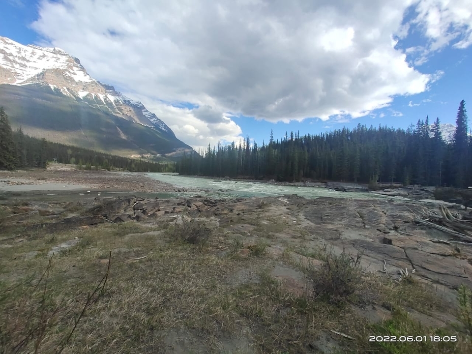 Un lit de rivière rocheux avec des montagnes au loin.
