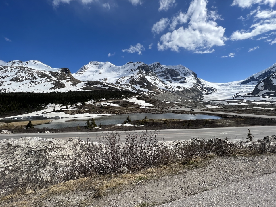 Mountains partially covered with snow against a blue sky.