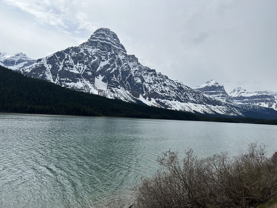 A lake and mountains under an overcast sky.