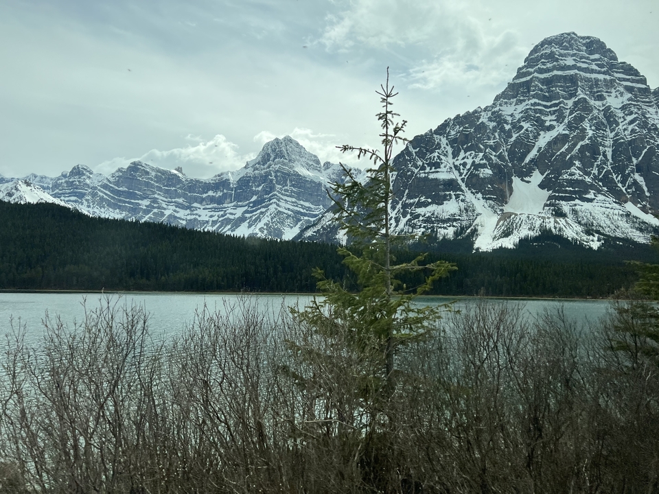 A snowy mountain with a lake in the foreground.