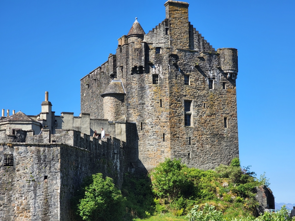 A historic stone castle under a clear blue sky.