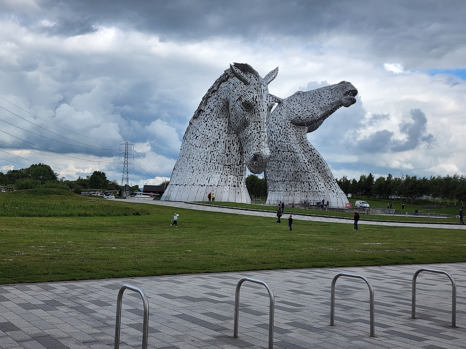 The Kelpies sculptures with people in the park area.