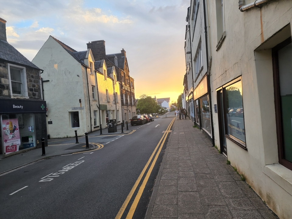 A sunset view of a charming street with buildings.