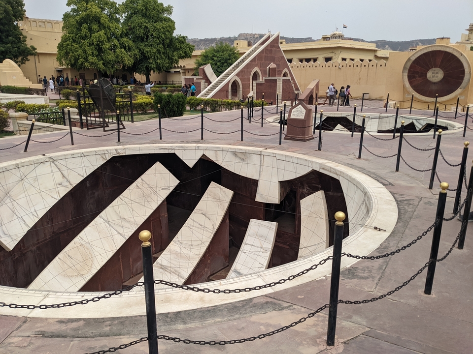 Tourists walking around large astronomical instruments.