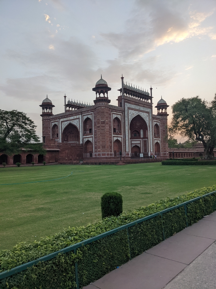 Historic red sandstone gate with intricate designs.