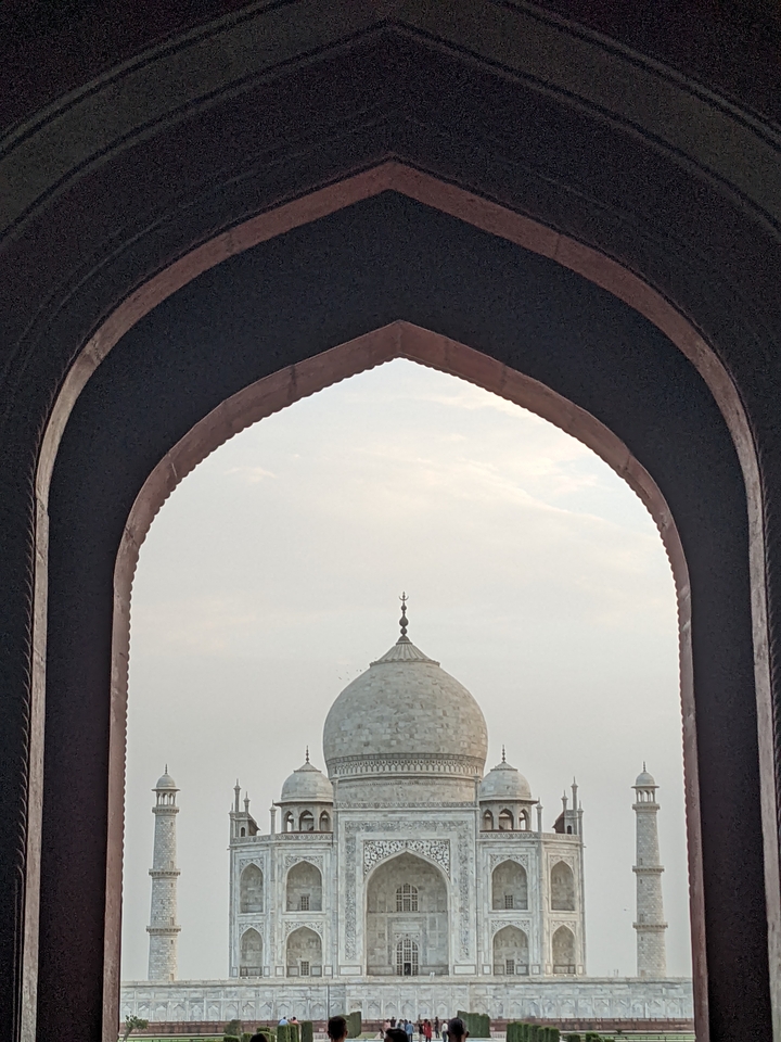 View through an arch framing a domed building.