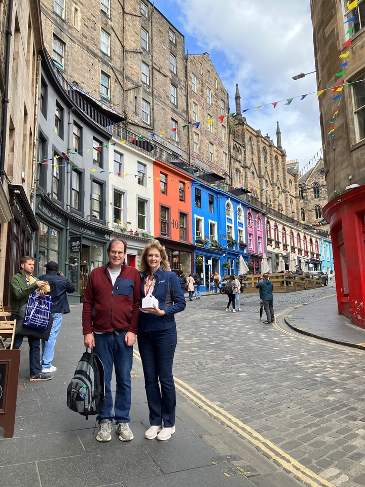 Couple posing on a colorful street with historic buildings.