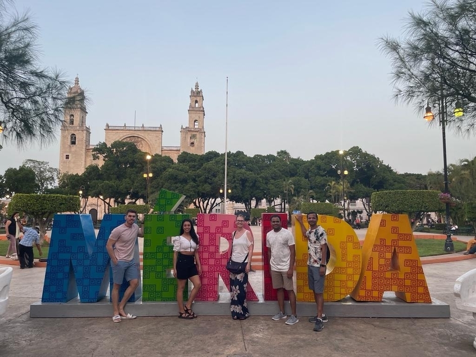 Group of people standing in front of colorful 'MERIDA' letters.